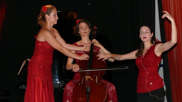 Glanznummer: Die drei von Les Troizettes musizieren an einem Cello. 