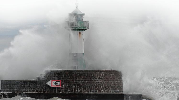 Eine Welle fegt über das zwölf Meter hohe Leuchtfeuer auf der 1440 Meter langen Mole auf der Insel Rügen hinweg. Das Klima hat sich in den vergangenen Jahrzehnten geändert. 