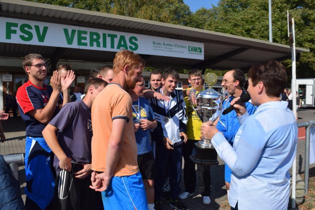 Angelika Hahn (r.) übergibt den Fußballern der Lebenshilfe Wittenberge den Wanderpokal für den Turniersieg. 