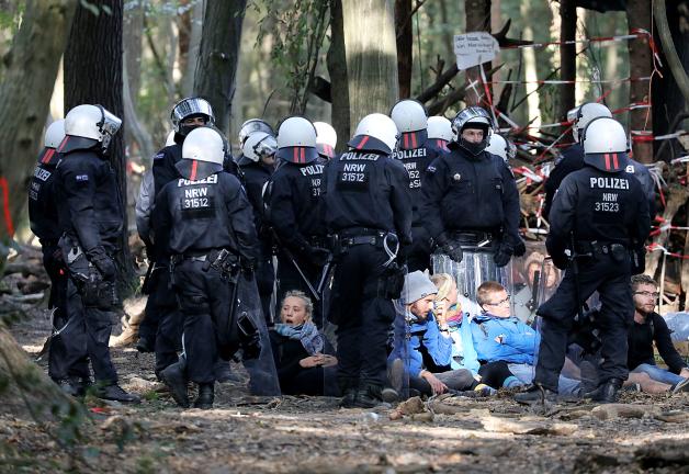 Polizisten haben eine Sitzblockade von Braunkohlegegenern eingekreist. Polizisten haben eine Sitzblockade von Braunkohlegegenern eingekreist.