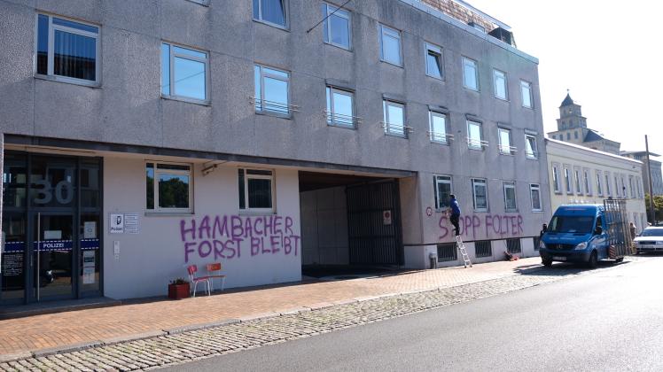 „Hambacher Forst bleibt“ und „Stoppt Folter“ steht in großen Lettern auf der Fassade des Polizeigebäudes. Mehrere Scheiben wurden eingeworfen.