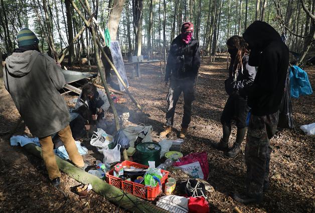 Aktivisten stehen im Hambacher Forst an einer Feuerstelle. Nach dem Abzug der Polizei sind zahlreiche Aktivisten in den Wald zurückgekehrt.