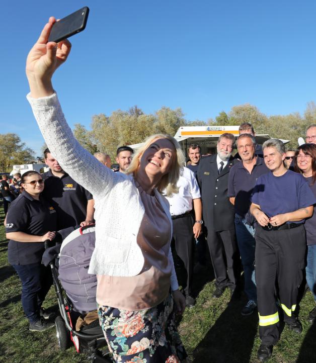 Manuela Schwesig macht ein Selfie mit dem Handy auf dem Familienfest für Feuerwehrleute. 
