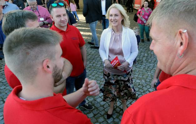 Manuela Schwesig (SPD, M.) unterhält sich mit Teilnehmern eines Familienfestes für Feuerwehrleute.