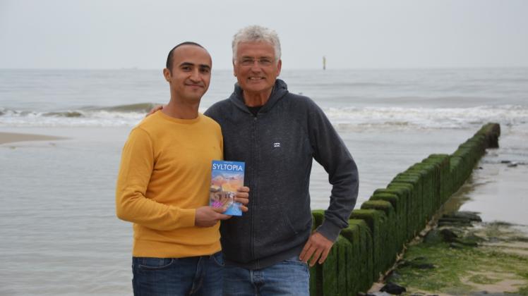 Doktorand Amr Aboelsoud (li.) und Autor Lothar Koch in Westerland am Strand. Beide verbindet das Buch „Syltopia“.
