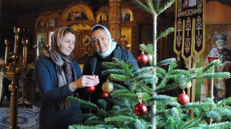 Schmücken den Tannenbaum in der russisch-orthodoxen Kirche an der Hamburger Allee: Ekaterina Witzel und Elena Fried (r.).  Das Gotteshaus aus Holz wurde im November 2012 geweiht. 