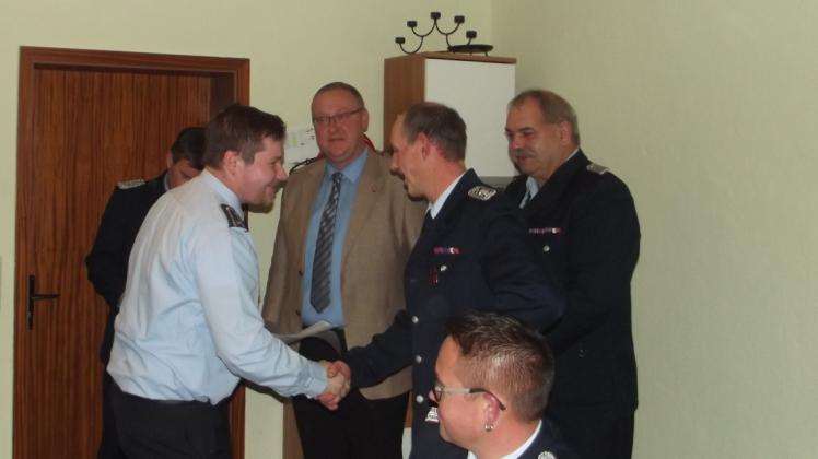 Detlef Stärke, stellvertretender Wehrführer (2.v.r), gratuliert Kai Hildebrandt zur Beförderung zum Brandmeister.