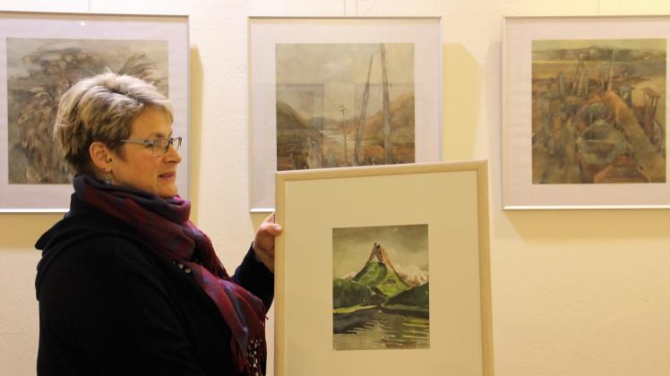 Anke Wessling mit Werken von Horst Schmedemann, im Hintergrund hängen Bilder von Helga Kaffke
