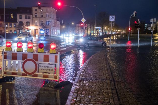 Straßen sind während der Sturmflut im Stadthafen von Wismar wegen Hochwasser gesperrt.