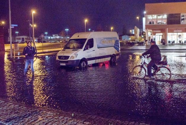 Ein Transporter steht auf einem von der Sturmflut leicht überschwemmten Parkplatz am Stadthafen von Wismar.