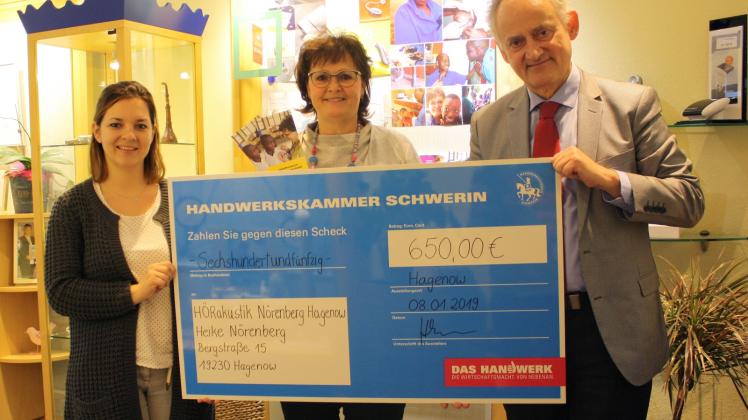 Dajana Welke (l.) und Edgar Hummelsheim von der Handwerkskammer Schwerin übergeben den symbolischen Scheck an Heike Nörenberg.    