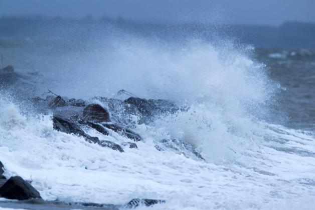 Wellen brechen über die Steinmole am Fischereihafen von Timmendorf auf der Ostseeinsel Poel.