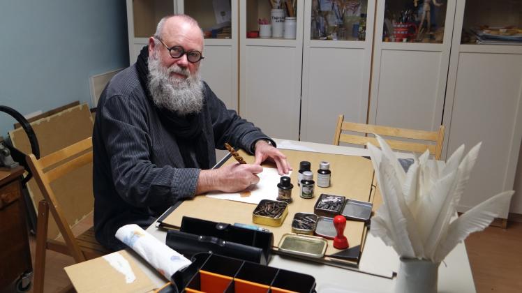 Zwischen Federn, Tinte und feinen Papieren: Graphiker Peter Möller bei der Arbeit in seinem Büro in Rastow.         