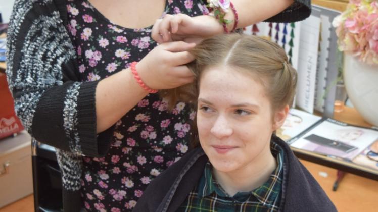 Auszubildende Melanie Reibe flechtet Alexandra Voigt (14) die Haare. Die 14-Jährige hat sich auf der Bildungsmesse über mögliche Praktika- und Ausbildungsstellen informiert. 