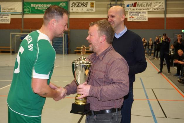Andreas Behrens übergibt den Pokal an Thomas Müller