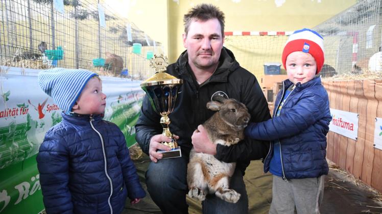 Tobi (l.) und Max blicken stolz zu ihrem Papa Andrè Kühling, der für seinen Hasen auf der Landesschau den Bürgermeisterpokal gewann.