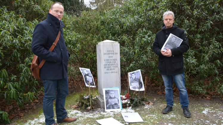 Anonymes Gemeinschaftsgrab für 209 Russen: Lars Hellwinkel (l.) und Jürgen Rönnau haben jetzt die ersten Gesichter ums Leben gekommener Kriegsgefangener neben die Stele gestellt. 