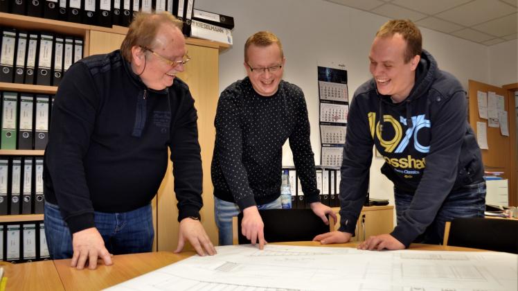 Sie haben gut lachen, der China-Auftrag ist perfekt: Norbert, Ralf und Roland Irrgang (v.l.) diskutieren ganz entspannt die Planungszeichnung für die Tribüne, die sie in Peking errichten. 