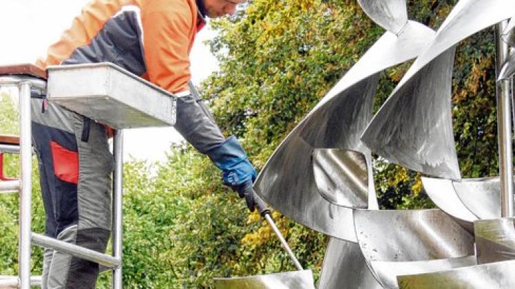 Putzaktion: Söhnke Springborn vom Technischen Zentrum rückte der Skulptur "Segel" von Will Brüll mit dem Hochdruckreiniger zu Leibe. Foto: Voiges  