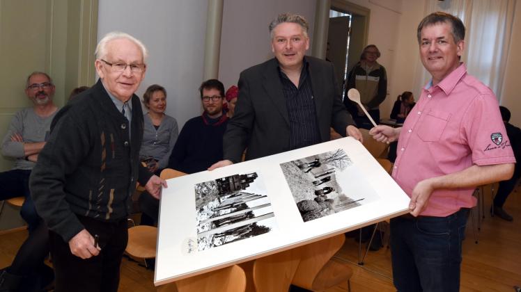 Unterschrift vom Fotografen: Nach der Versteigerung signierte Ernst Höhne auch die beiden Bilder, die sich Dirk Grünig ausgesucht hatte. Auktionator Volker Janke benutzte statt eines Hammers einen Holzlöffel, um den Zuschlag zu erteilen. 