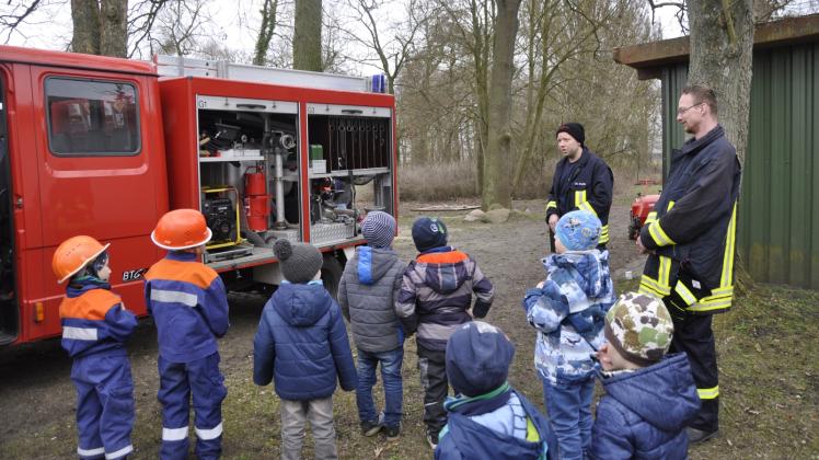 Jugendwart Christian Klein erklärt den Kindern das Feuerwehrfahrzeug.