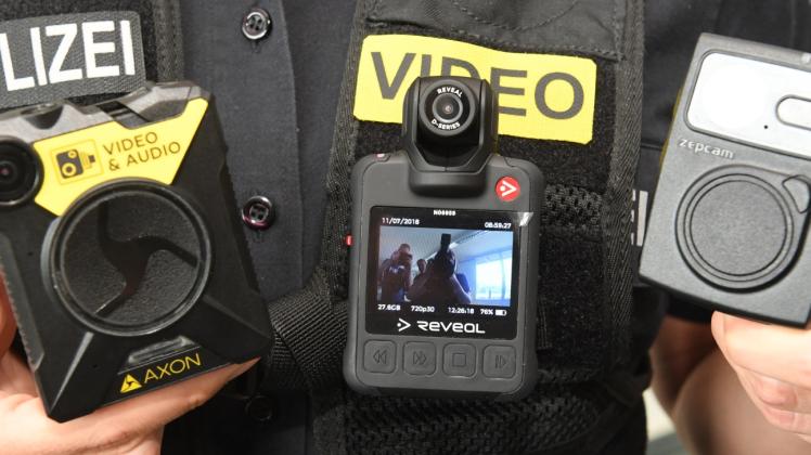 Eine Polizistin zeigt am Rande einer Pressekonferenz drei verschiedene Bodycams. Der Landesdatenschutzbeauftragte hat harsche Kritik am Gesetzentwurf zum neuen Sicherheits- und Ordnungsgesetz (SOG) geübt. 