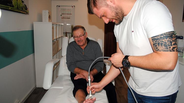 Behandlung im Wundzentrum in Güstrow: Felix Grasshoff (r.) kümmert sich mit dem Plasma-Pen um die Wunde von Lothar Schulz. 