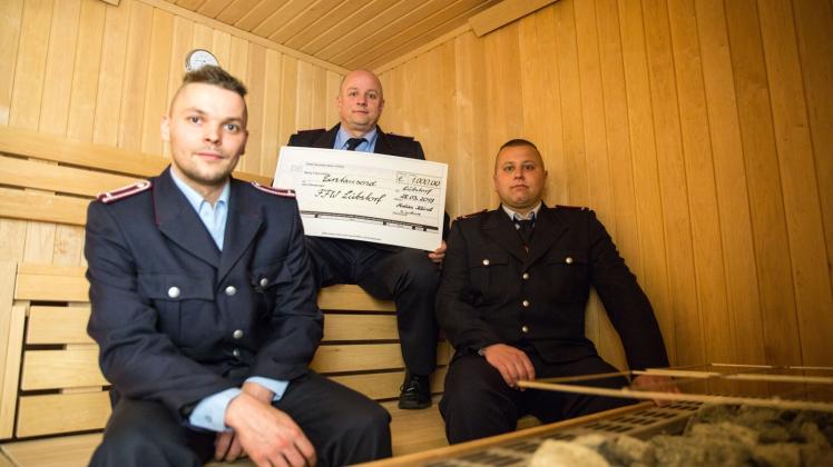 Drei Feuerwehrmänner aus Lübstorf in der Sauna: Sandro Rietentiet (M.) verteilt die Spende an die Wehren. 