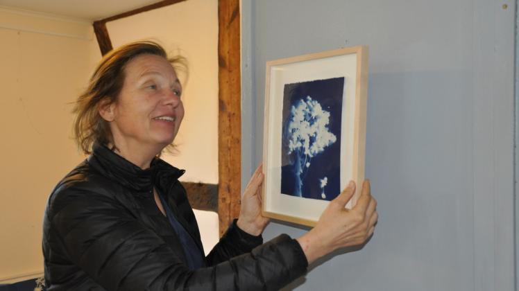 Kerstin Weßlau bringt ihren Fotogramme in der Galerie an. 
