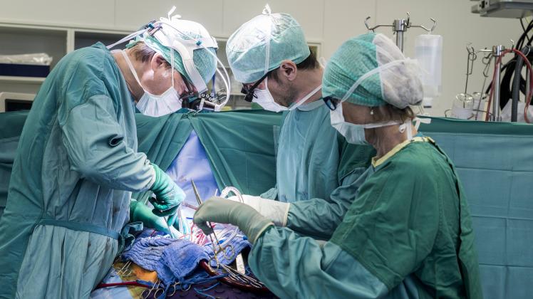 Heart surgeons and operating room nurse during a heart valve operation model released Symbolfoto pro