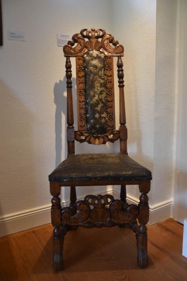 Die dänische Krone ziert den Stuhl oben an der Rückenlehne sowie zwischen den beiden vorderen Stuhlbeinen. Rückenlehne und Sitzfläche sind gepolstert und mit Leder überzogen. Die dänische Krone ziert den Stuhl oben an der Rückenlehne sowie zwischen den beiden vorderen Stuhlbeinen. Rückenlehne und Sitzfläche sind gepolstert und mit Leder überzogen.