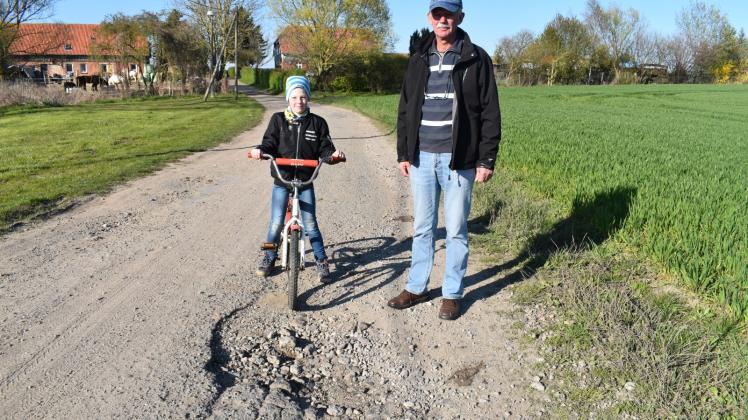 Eine besonders verschlissene Stelle der Straße durch Lissow-Bau zeigen Walter Lindemann und sein Enkel Max.