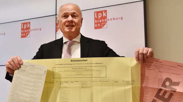 Landeswahlleiter Bruno Küpper hält in der Landespressekonferenz Musterwahlzettel in den Händen.