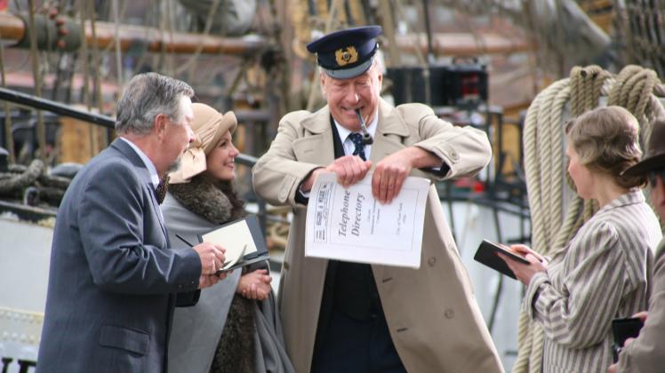Spielszene im Alten Hafen von Wismar vor der „Fridtjof Nansen“:  Graf von Luckner – gespielt von Martin von Wieck – zerreißt auf Bitten amerikanische Reporter ein Telefonbuch. 