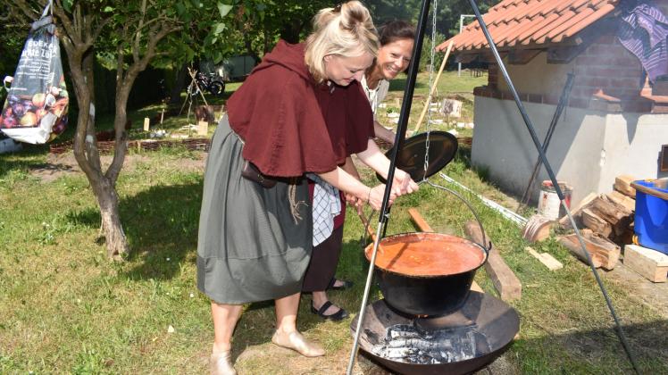 Am Backhaus des Jugendclubs: Die Lehrerinnen Maren Lüth und Petra Paul (von links) schauen nach, ob das Chili con carne kocht. Es ist für die Teilnehmer am Mittelalter-Projekt der Regionalen Schule Schwaan gedacht.