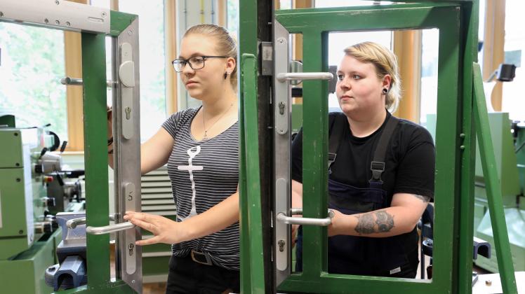 In der Metallmaschinenwerkstatt im Handwerkerbildungszentrum üben die Auszubildenden Sarah Gutzmann (19) (v.l.), künftige Metallbauerin, und Maria Mertins (23), künftige Konstruktionsmechanikerin, den Einbau von Schlössern und Rahmen. 