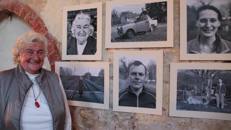 Erst nicht ganz zufrieden, dann übers ganze Gesicht strahlend: Renate Dübner vor ihrem Porträt und den Bildern ihrer Familie. 