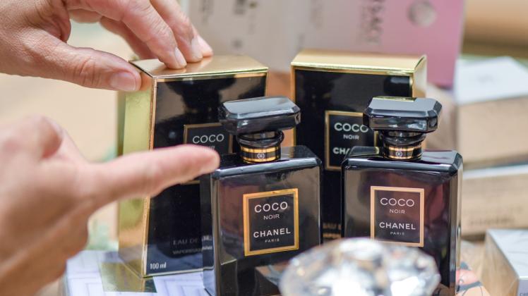 Martin Ruppmann zeigt eine gefälschte Parfüm-Flasche (l) der Marke Chanel. 