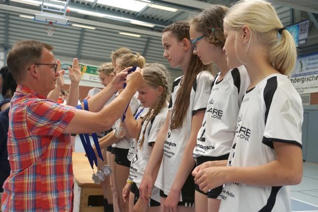 Der vor zwei Wochen neu gewählte Präsident des 1. VC Parchim, Thomas Dieckemann, überreicht „seinen Volleyball-Mädels“ die Silbermedaillen.