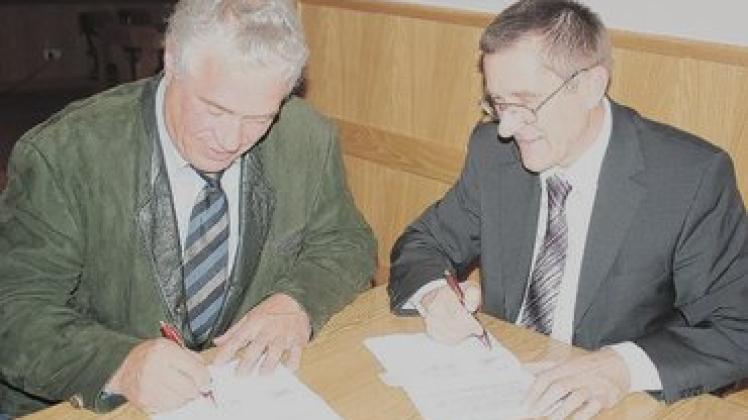 Amtsvorsteher Paul Friedrich Beeck und VSG-Chef Heinz Grothkopp (r.) unterzeichnen die Wegenutzungsverträge.  Foto: fsh