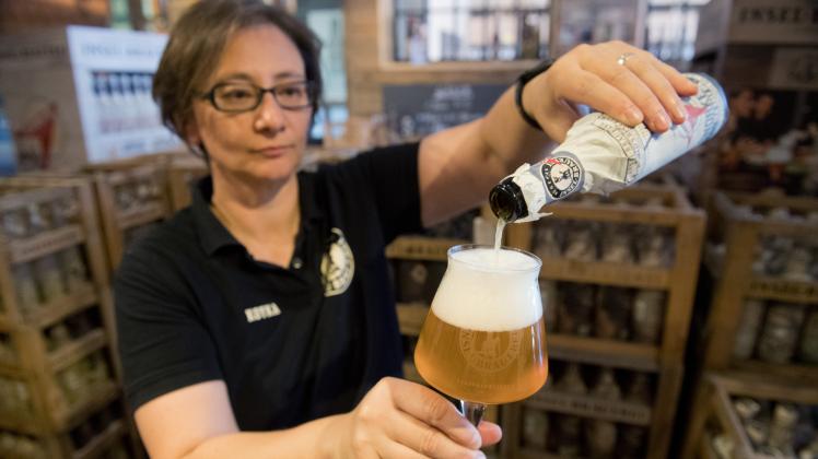 Koyka Stoyanova, Mitarbeiterin der Insel-Brauerei in Rambin auf der Insel Rügen, präsentiert im Lagerverkauf ein Glas Bier mit einer alkoholfreien Biersorte. 