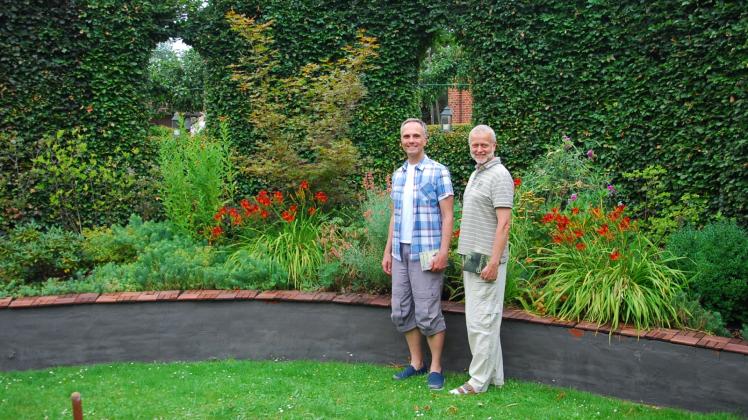 Einer der Leseorte: Frank Friedrichs und Matthias Teut (r.) stehen auf dem Rasen in einem der Gartenzimmer – umgesäumt von einer hohen Hecke.  