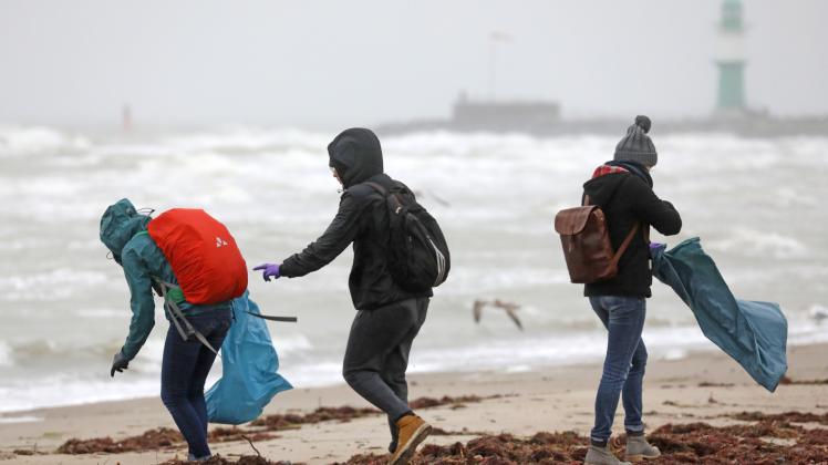 Teilnehmer einer Müllsammelaktion am Warnemünder Ostseestrand 