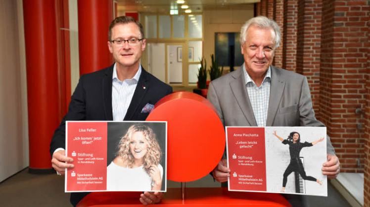 Dr. Sören Abendroth (links) und Rolf Teucher mit den Plakaten der Kabarettistinnen Lisa Feller und Anna Piechotta.