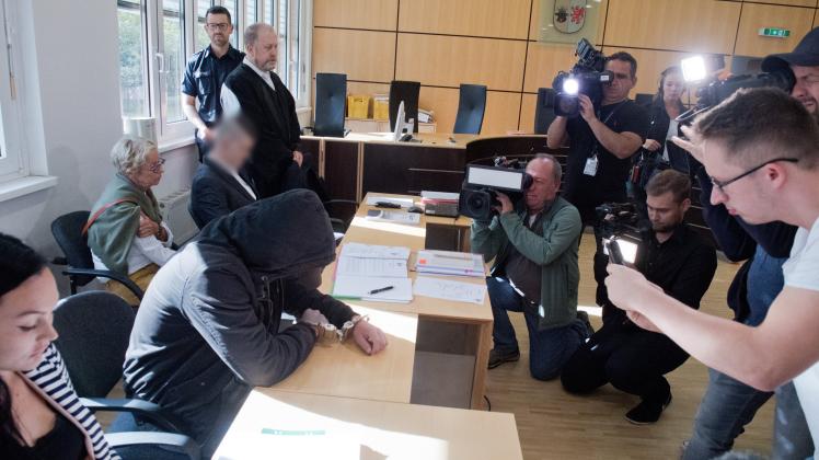 Der 19-jähriger Angeklagte (2.v.l.) verbirgt im Gerichtssaal im Landgericht sein Gesicht. Für den Mord an der 18-jährigen Maria aus Zinnowitz auf Usedom müssen sich am selben Tag der 19- und ein 21-Jähriger (4.v.l.) vor dem Gericht verantworten. 