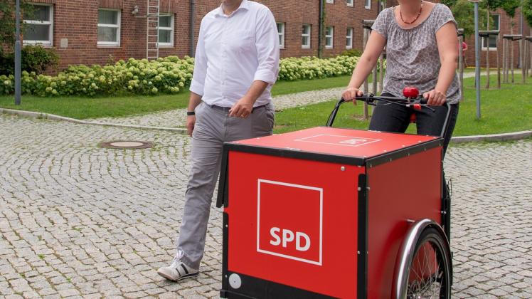 Klara Geywitz rollt gemeinsam mit SPD-Generalsekretär Lars Klingbeil mit einem Lastenfahrrad mit dem Logo der SPD über das Gelände der Filmstudios Babelsberg. 