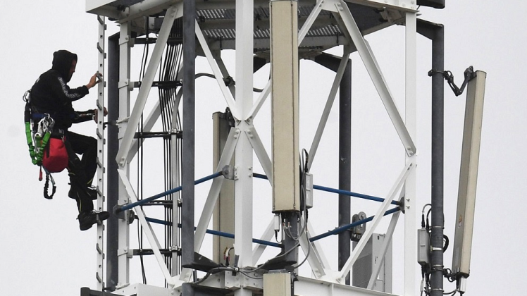 Luftiger Arbeitsplatz: Ein Techniker klettert an einem Funkmast neben den Mobilfunkantennen für den Mobilfunkstandard 5G in Mellenthin. 