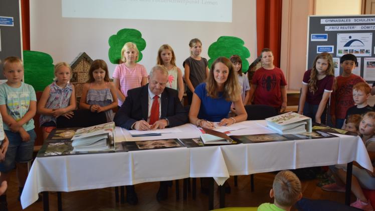 Unterschrift vor jungem Publikum: Bettina Martin und Till Backhaus unterzeichnen in Dömitz die Vereinbarung über den Unterricht im Wald.