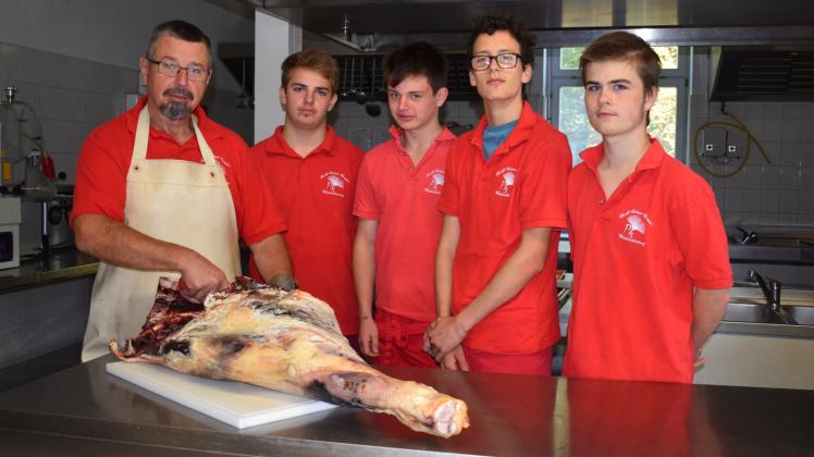 Lehrvorführung an der Rinderkeule: Christian Schäfer bringt André, Evan, Robin und Sebastian das Fleischzerlegen bei.