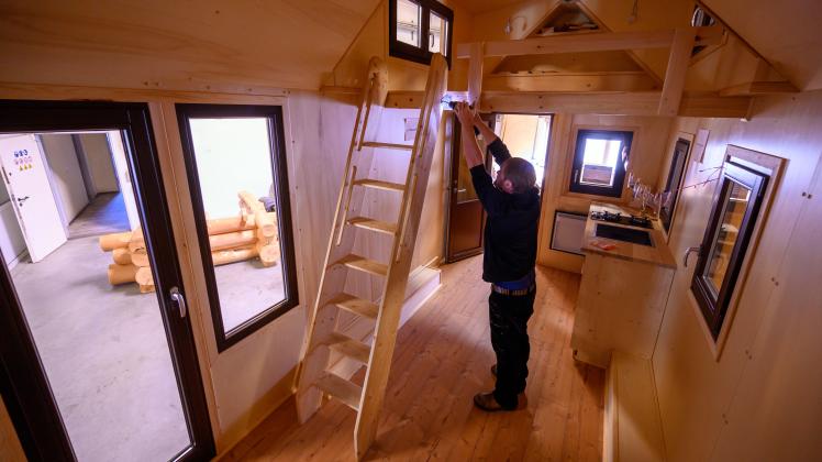 Benjamin Glowatzki schraubt in einem Tiny House die Leiter zum Hochbett fest. Die mobilen Eigenheime werden seit Jahresbeginn in Ludwigslust produziert.